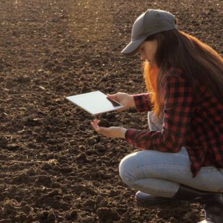 Boerin met ipad op land meststoffen akkerbouw tuinbouw