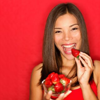 vrouw die aardbeien eet (food)