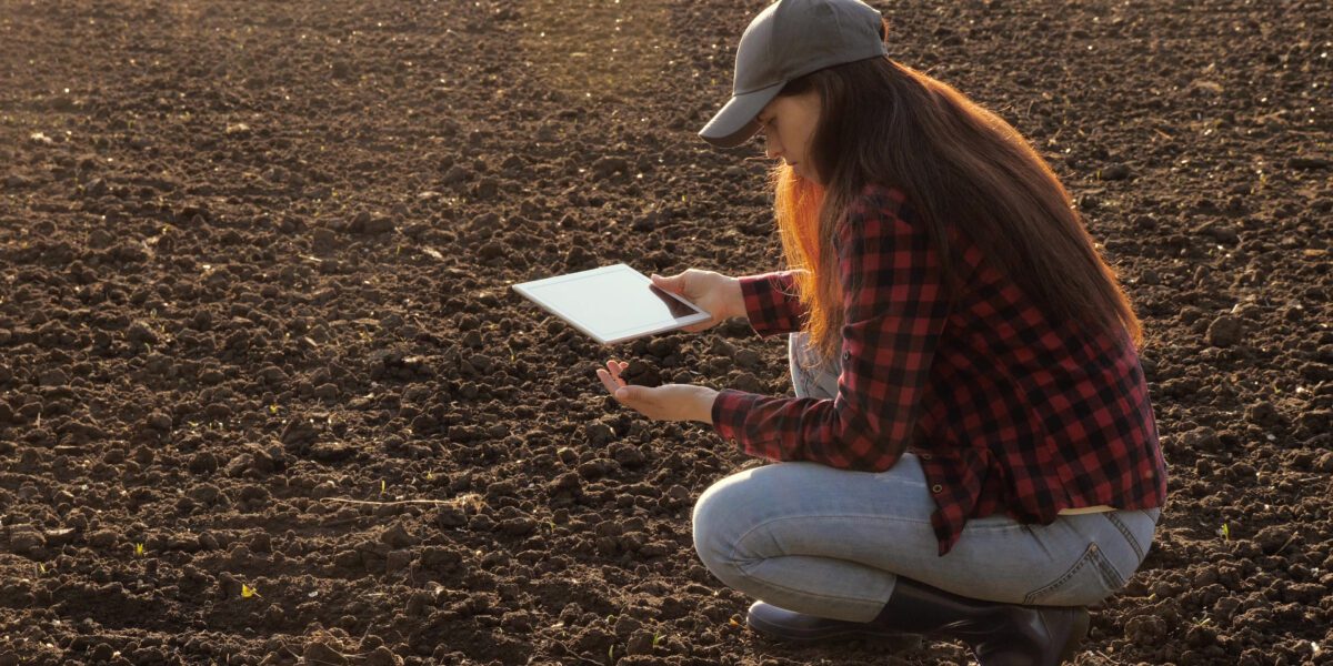 Woman,Farmer,With,A,Tablet,In,Field,Holds,Earth,In